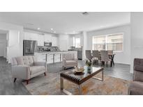 Bright living room with open floor plan, featuring modern decor and a stylish kitchen in the background at 6328 Whip O Will Ln, St Cloud, FL 34771