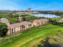 Beautiful exterior view of the apartments with a picturesque lake and city skyline in the background at 7511 Seurat St # 10207, Orlando, FL 32819