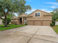 Charming home featuring a three-car garage, stone accents and a well-manicured lawn at 7513 Brightwater Pl, Oviedo, FL 32765