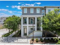 Charming three-story townhome featuring a modern design with lush landscaping and a welcoming entrance at 8478 Karrer Ter, Orlando, FL 32827