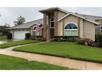 Charming single-Gathering home with manicured lawn, beautiful landscaping, and an American flag at 872 Silverwood Dr, Lake Mary, FL 32746