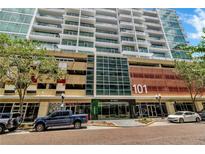 Exterior of building featuring street-level retail, parking and residential units at 101 S Eola Dr # 810, Orlando, FL 32801