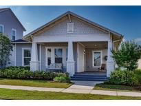 Charming single-story home featuring a welcoming front porch, manicured lawn, and attractive architectural details at 1212 Civitas Way, Winter Garden, FL 34787