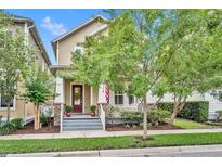 Charming two-story home featuring a covered front porch with classic columns and a well-manicured front yard at 1356 Coralstone Dr, Celebration, FL 34747