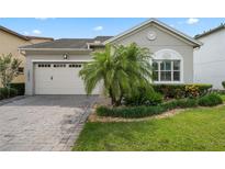 Charming home featuring a two-car garage, paver driveway, complemented by a well-manicured lawn and tasteful landscaping at 14072 Alafaya Oak Bnd, Orlando, FL 32828