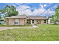 Charming home featuring stone accents, a well-manicured lawn, and welcoming walkway at 150 Tarpon Cir, Winter Springs, FL 32708