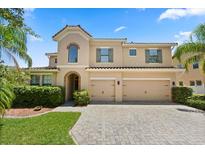 Stunning two-story home featuring a tile roof, three-car garage, and beautifully paved driveway at 1501 Prairie Oaks Dr, St Cloud, FL 34771