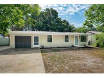 Charming single-story home with a freshly painted facade, attached garage, and simple landscaping at 1957 Deloy Dr, Daytona Beach, FL 32119