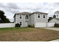 Two-story home with attached two-car garage and fenced yard on an overcast day at 2381 Courtland Blvd, Deltona, FL 32738