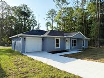 Charming single-story home with a one-car garage and a spacious concrete driveway at 4919 Nw 61St Ct, Ocala, FL 34482