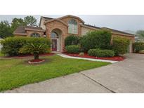 Charming two-story brick home with a landscaped front yard and a red front door at 508 Key Ct, Orlando, FL 32828