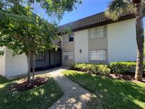 Charming condo building featuring lush landscaping and a welcoming walkway at 51 Windtree Ln # 101, Winter Garden, FL 34787