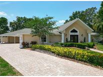 Charming home showcasing its landscaped front yard with a brick driveway at 5852 Medinah Way, Orlando, FL 32819