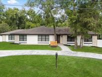 A charming one-story home boasts a well-manicured front yard and beautiful stone accents at 625 N Central Ave, Oviedo, FL 32765