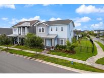 Charming two-story home featuring a landscaped yard, complemented by blue sky and manicured lawn at 6875 Bridgman St, Orlando, FL 32827