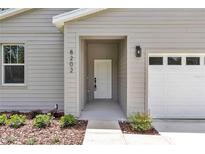 Inviting front entrance with well-maintained landscaping and neutral siding at 8202 Sw 123Rd Ter, Dunnellon, FL 34432