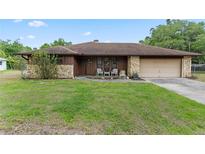 Charming home features stone accents, a cozy porch, and a well-manicured lawn at 10059 Sali Dr, Orlando, FL 32817