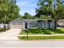 Charming single-story home with a well-maintained lawn, attached garage, and lovely landscaping at 1014 Seminole Creek Dr, Oviedo, FL 32765