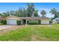 Charming single-story home with a well-manicured lawn and an American flag proudly displayed out front at 102 Old Hickory, Longwood, FL 32750