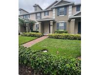 Charming townhome featuring a well-maintained lawn and lovely landscaping at 14531 Pleach St, Winter Garden, FL 34787
