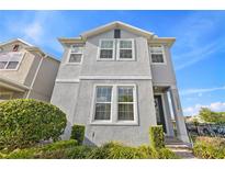 Charming two-story home featuring gray stucco, white trim, and manicured landscaping at 15358 Arcadia Bluff Loop, Winter Garden, FL 34787