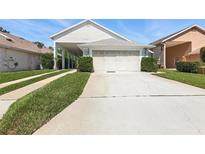 Charming home featuring a two-car garage, manicured lawn, and meticulous landscaping at 1548 Challenger Ave, Davenport, FL 33897