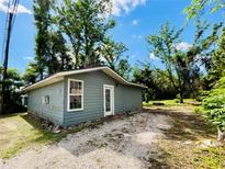 Charming home featuring a light blue exterior and gravel landscaping with trees at 2414 E Orange Ave, Eustis, FL 32726