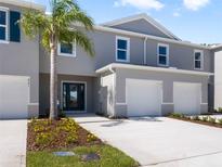 Charming townhome featuring a two-car garage, manicured lawn, and a welcoming entrance, all bathed in sunlight at 2710 Golden Trout Ln, Edgewater, FL 32141