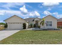 Charming single-story home featuring a well-maintained lawn and attached two-car garage at 322 Huron Dr, Kissimmee, FL 34759