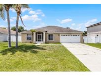 Charming single-story home with a well-maintained lawn, two-car garage, and inviting entryway at 460 Flamingo Ct, Kissimmee, FL 34759