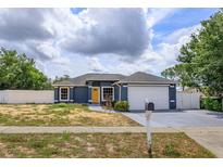 Charming single-story home with a well-maintained lawn and a bright yellow front door at 4843 Pierce Arrow Dr, Apopka, FL 32712