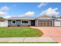 Charming single-story home featuring a brick driveway, gray facade and well-maintained lawn at 5338 Tangerine Ave, Winter Park, FL 32792