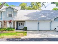 Charming light blue townhome with a two-car garage and well-maintained front lawn at 5395 Dover Village Ln # 305, Orlando, FL 32812