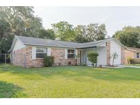 Charming single-story brick home with well-maintained lawn and mature trees, offering classic curb appeal at 635 San Lanta Cir, Sanford, FL 32771