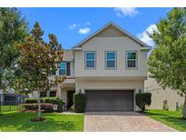 Two-story home with a well-manicured lawn and a brick driveway leading to a two-car garage at 646 Marsh Reed Dr, Winter Garden, FL 34787