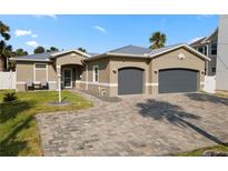 Charming single-story home featuring a two-car garage, a neatly landscaped front yard, and a paved driveway at 725 N Grandview Ave, Daytona Beach, FL 32118