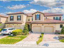 Inviting Mediterranean-style townhome featuring a tile roof and well-manicured landscaping at 8122 Roseville Rd, Davenport, FL 33896
