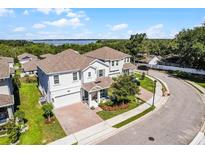 Beautiful two-story home featuring a manicured lawn and a brick-paved driveway at 1123 Dora Parc Ln, Mount Dora, FL 32757
