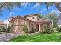 Charming two-story home featuring a red tile roof and an attached two car garage at 1166 Adair Park Pl, Orlando, FL 32804