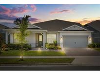Charming single-Gathering home with well-manicured lawn and inviting front entrance at dusk at 13462 Panama Beach Ct, Orlando, FL 32827