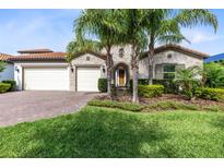 Beautiful exterior view of home with landscaped front yard and palm trees at 16696 Otterchase Ln, Winter Garden, FL 34787