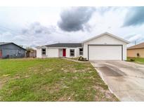 Charming single-story home with a well-maintained lawn and a bright red front door at 2486 Ainsworth Ave, Deltona, FL 32738
