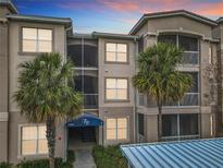 Lovely exterior shot of a 3-story building showcasing large windows, palms and an inviting entryway for potential residents at 3000 Laurel Park Ln # 202, Kissimmee, FL 34741