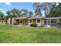 Charming single-story home featuring a stone facade, mature trees, and screened pool enclosure at 360 Pineview St, Altamonte Springs, FL 32701
