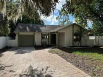 Charming single-story home featuring a brick driveway and well-maintained landscaping, set beneath mature trees at 3739 S Fern Creek Ave, Orlando, FL 32806