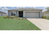 Charming single-story home featuring a well-manicured lawn and a two-car garage at 392 Citrine Loop, Kissimmee, FL 34758