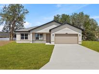 Charming single-story home featuring a two-car garage, well-manicured lawn, and neutral-toned exterior at 508 Churchill Pl, Poinciana, FL 34759