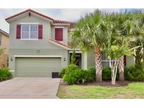 Charming two-story home featuring a well-manicured lawn and beautiful landscaping, offering great curb appeal at 5273 Oakbourne Ave, Davenport, FL 33837