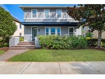 Charming two-story home with well-manicured lawn and attractive landscaping enhancing its curb appeal at 8692 Tavistock Lakes Blvd, Orlando, FL 32827