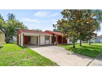 Charming single-story home features a red tile roof and a spacious front yard with mature trees at 10169 Matchlock Dr, Orlando, FL 32821